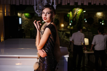 Portrait of 20s style festive beauty in a restaurant