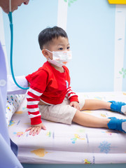 Doctor examining a little boy by stethoscope