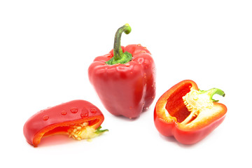 Ripe fresh organic bell pepper, half and a quarter bell peppers in dew drops, isolated on a white background
