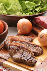 bifes de churrasco de picanha com folhas de alface ao fundo