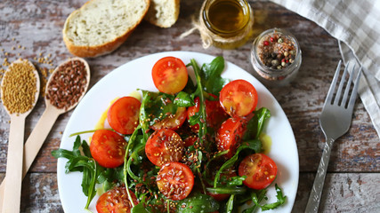 Healthy salad with arugula, cherry tomatoes and seeds. Diet concept.