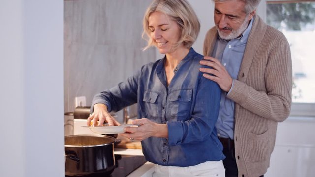 Slow motion shot of woman holding a plate with tortellini in kitchen