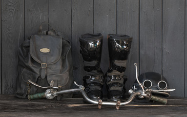 black leather biker boots on black wooden background