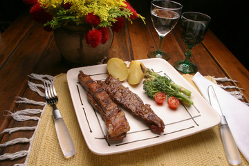 churrasco de bife de tiras acompanhado de batatas e brocolis