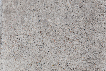 The gray texture of the concrete. Lines, points, pebbles, and holes in the concrete. Abstract grey grunge background.