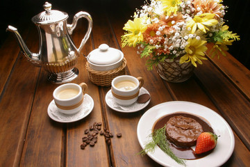 Obraz na płótnie Canvas Mesa com xícaras de café e sobremesa de mousse de chocolate com morango
