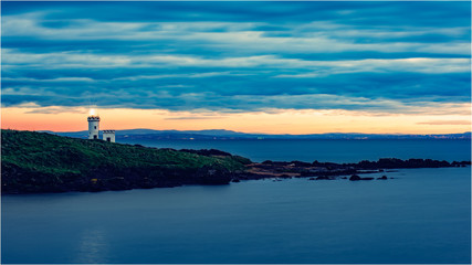 Fototapeta na wymiar Elie cloudy sunset with lighthouse 