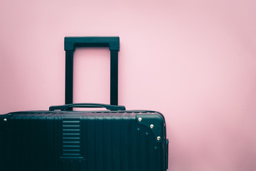 Black luggage on pink background for travel and journey concept
