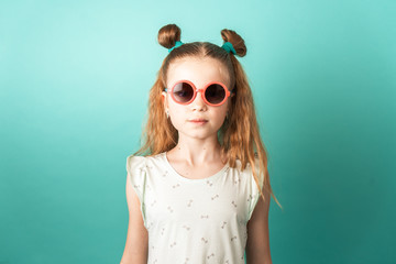 Bright colors: a girl in sunglasses on a green background.