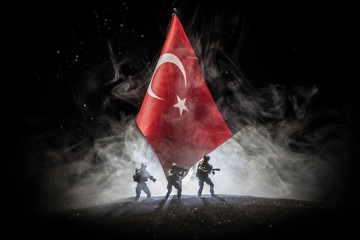 Silhouette of soldier with rifle against a turkish flag. Selective focus