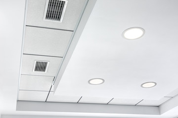 multi-level ceiling with three-dimensional protrusions and a suspended tiled ceiling with a built-in round led light and grille ventilation system.