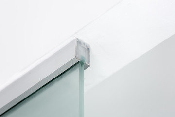 metal fastening to the ceiling of a glass partition, closeup of interior details.