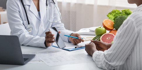 Nutritionist showing patient blank smartphone screen while consultancy
