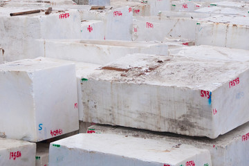 Raw italian marble blocks stocked in the Carrara harbor ready to be shipped