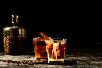 Iced coffee with milk on a dark background. Coffee with ice and cream on a gray background close-up.