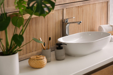 Stylish vessel sink near wooden wall in modern bathroom
