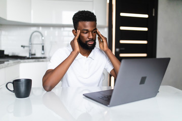 Young frustrated unhappy tired african american man with financial troubles, with laptop sitting at...
