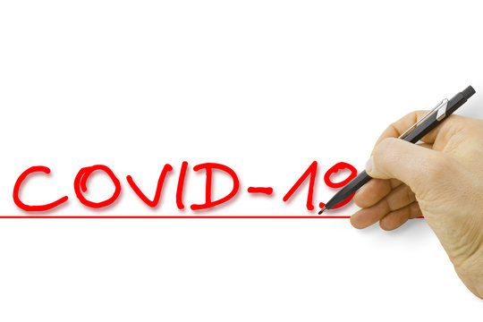 Hand writing coronavirus COVID-19 text on white background - concept image