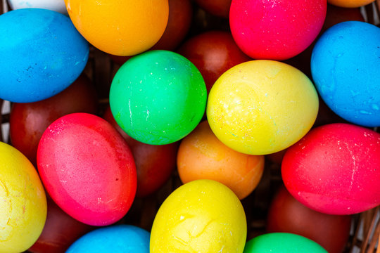 Background image of multi-colored Easter eggs. Background of colored chicken eggs close-up, top view.