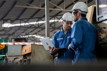 Factory engineer checking the machine and reading report by laptop computer, Annual maintenance concept