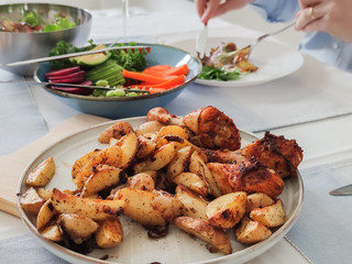 Festive served table with healthy colorful vegetables and baked potato and chicken at family dinner
