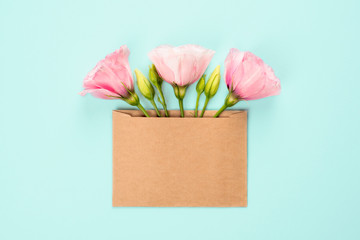 Three Eustoma flower arrangement with flowers and blank card, on blue background