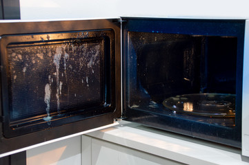 Shot of a door microwave full of dirty at home