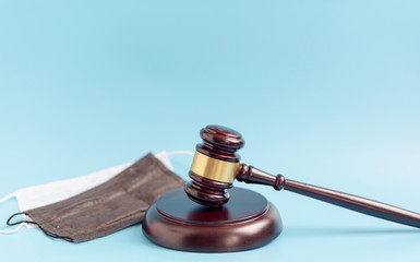  brown gavel and medical protective masks on a blue background