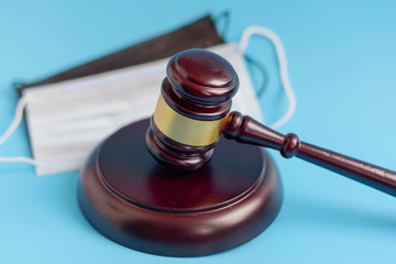  brown gavel and medical protective masks on a blue background