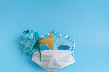 carnival mask in a protective medical mask on a blue background