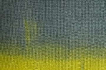 Close up view of knitted material colored in yellow turning into blue. Yellow blue background.