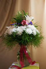 White lilyes, yellow and pink orchids, branch of lilac, chrysanthemums in the spring  tender bouquet on the background with green curtain