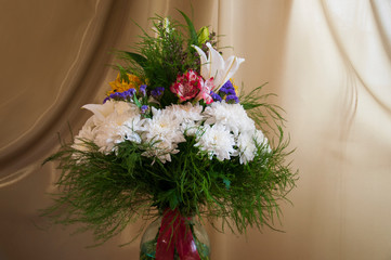 White lilyes, yellow and pink orchids, branch of lilac, chrysanthemums in the spring  tender bouquet on the background with green curtain