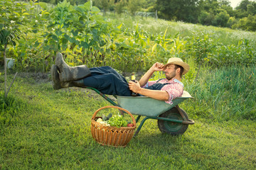 Funny farmer resting in wheelbarrow