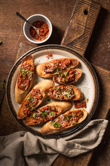 Italian bruschetta with olive paste, parmesan cheese and fresh oregano leaves. Rustick, wooden background.