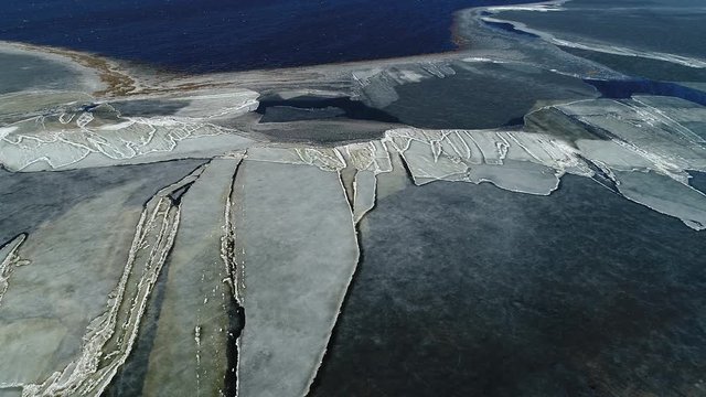 Moving ice plates in spring on lake Burtnieks ice shove aerial view