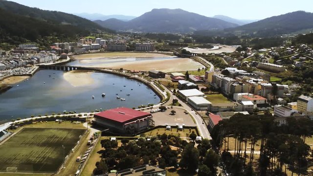 Aerial view of the bay at the end of Ria de Viveiro crossed by Puente Mayor, Viveiro, Lugo, Galicia. Spain. Drone rotating from left to right