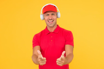 Let music speak. Happy man give thumbs ups yellow background. Enjoying favorite music. Handsome guy wear headphones playing music. Listening to music and singing along to song