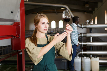 Woman winemaker checking new wine