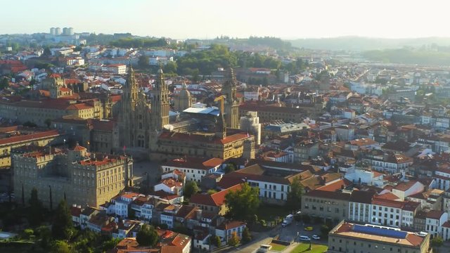 Aerial, pan, drone shot overlooking the Cathedral of Santiago de Compostela and the cityscape, golden hour, in Saint James of Compostella, Galicia, Spain