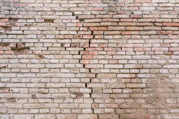 ancient building with cracks in wall made of red bricks located in historical building
