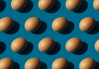 Eggs on blue background, strong light shadows.