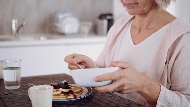 Slow Motion Shot Of Mature Woman Preparing Pancake With Nuts