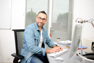 handsome young happy and successful businessman in casual wear at office business desk