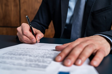 A man broker signing the mortgage contract at the real property agent office. The concept of...