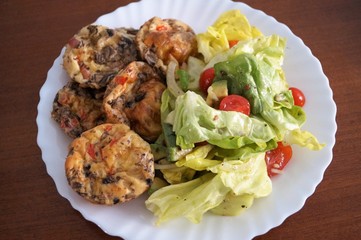 healthy Breakfast muffins scrambled eggs with spring vegetable salad served on a white round plate