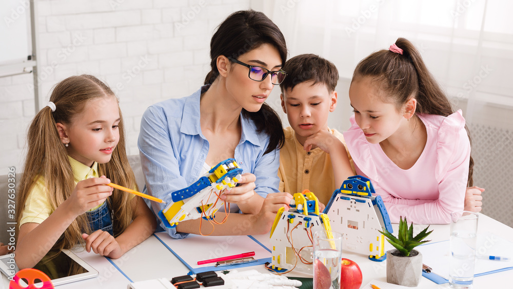 Poster Children learning about computers and robots with their teacher