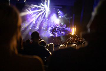 Lights on stage during concert in hall filled with spectators