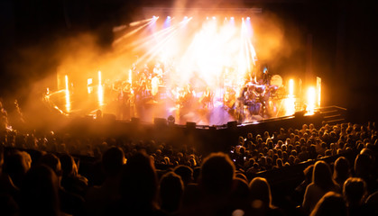 Lights on stage during concert in hall filled with spectators