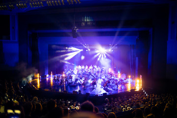 Lights on stage during concert in hall filled with spectators